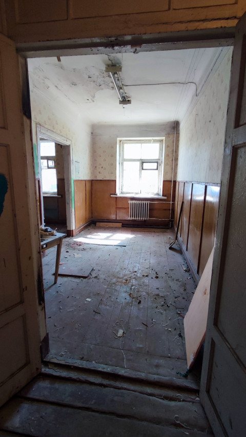 Комната со старым деревянным полом и повреждённым потолком