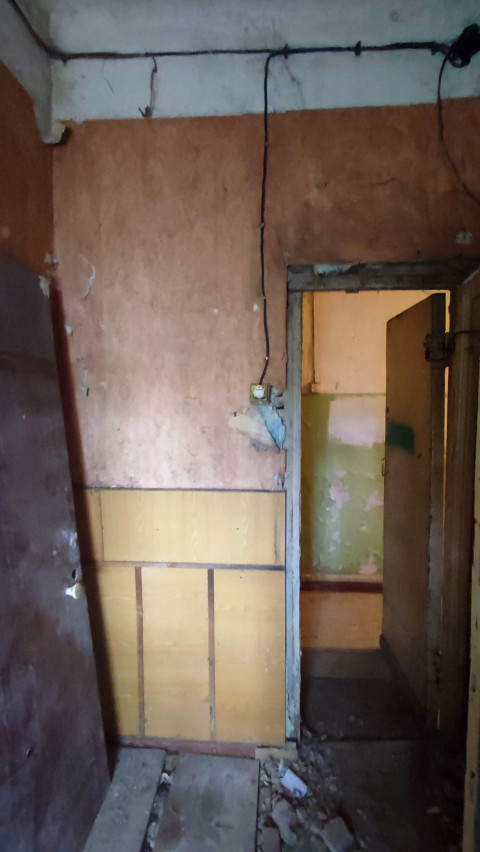 Дверной проём с оголённым проводом и электроузлом в старом помещении