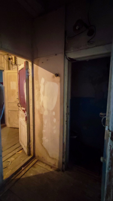 Коридор со старыми дверями и повреждёнными стенами