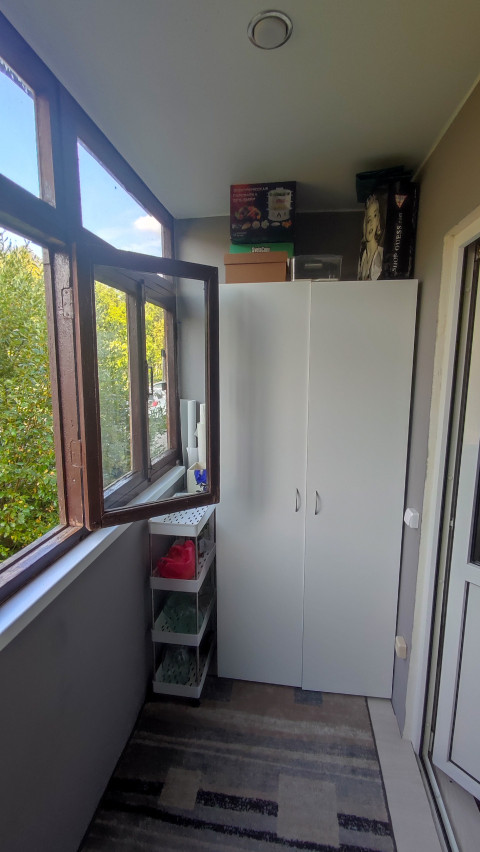 Лоджия со шкафом, стеллажом и открытым окном для проветривания