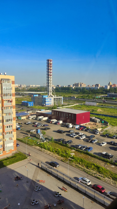 Промзона с дымовой трубой и парковкой, вид сверху
