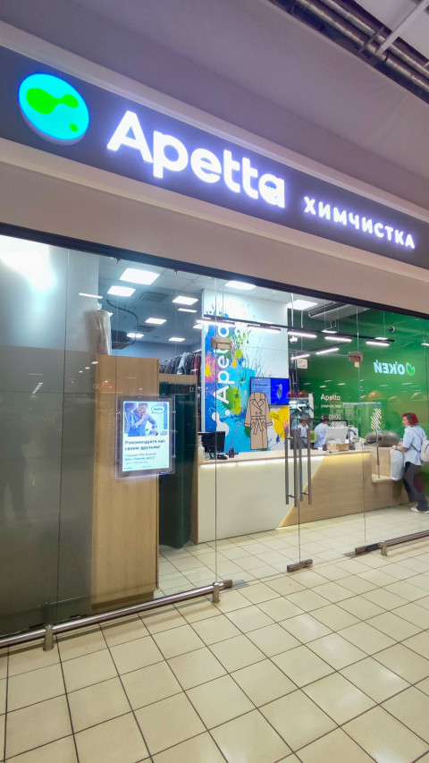 Вывеска Apetta химчистка и стеклянная витрина в галерее торгового центра
