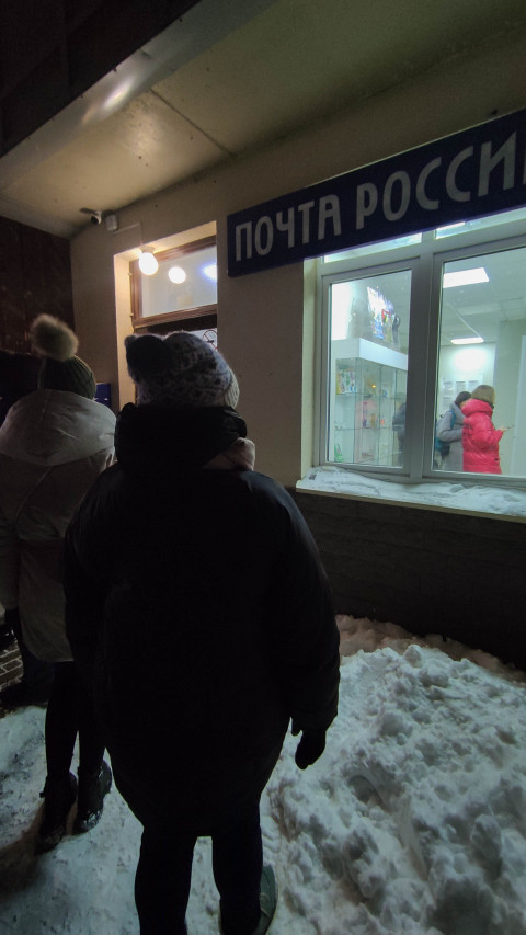 Очередь перед отделением Почты России в зимний вечер