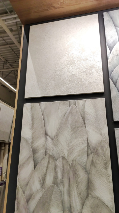 Образцы обоев с рельефной и растительной текстурой в магазине