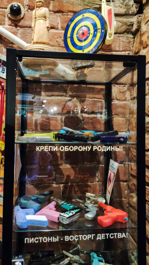 Экспозиция с пистонами и игрушечным оружием в ретро-оформлении