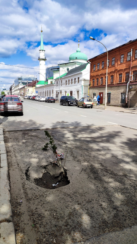 Асфальт с ямой и Галеевской мечетью на заднем плане в Казани