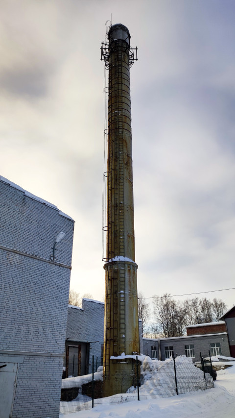 Промышленная дымовая труба на фоне зимнего цеха