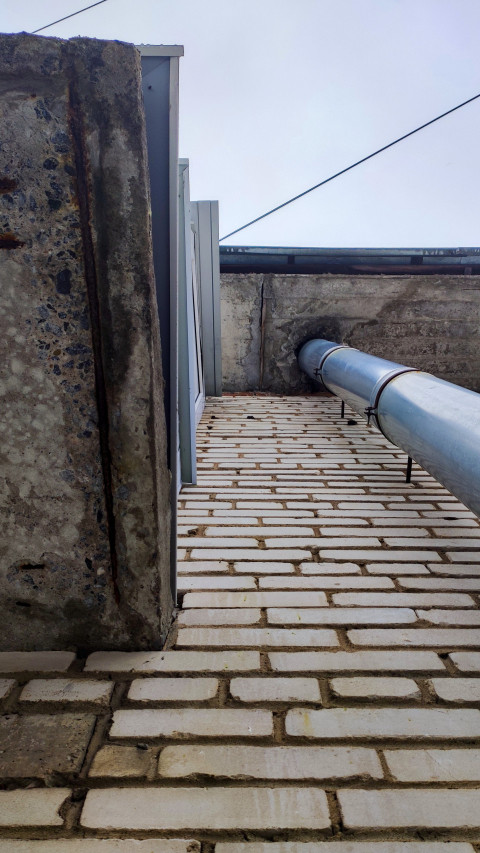 Примыкание трубы к фасаду с признаками старения материала