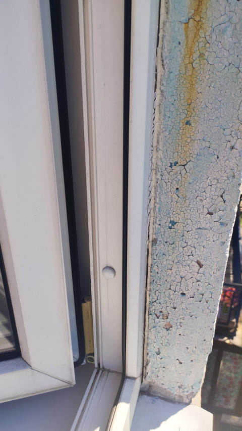 Оконный проем с пластиковым стеклопакетом и поврежденной внешней отделкой