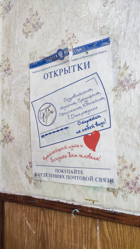Старый рекламный лист «Открытки» Почты России, закреплённый скотчем на стене