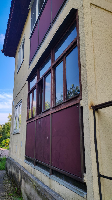 Крупный план остекления лоджии с деревянными рамами и цветными панелями