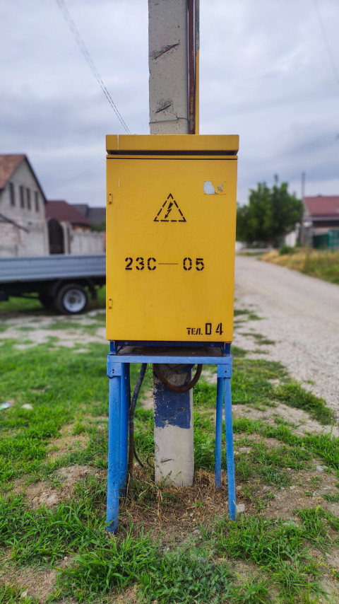 Вертикальный кадр уличного электрощита на бетонной опоре