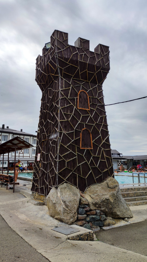 Декоративная башня в стиле крепости рядом с бассейном комплекса