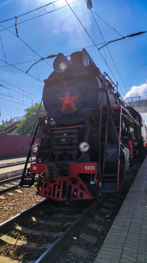 Низкий ракурс передней части паровоза ЛВ-0233 под проводами контактной сети