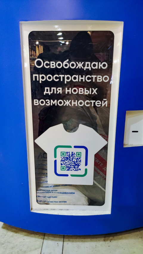 Изображение футболки с QR-кодом на аппарате по сбору старой одежды