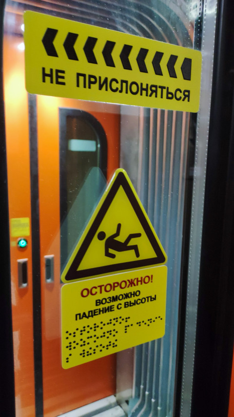 Желтые знаки осторожности на двери поезда