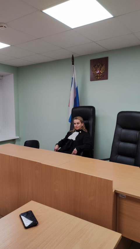 Судья сидит за столом в зале суда во время слушания