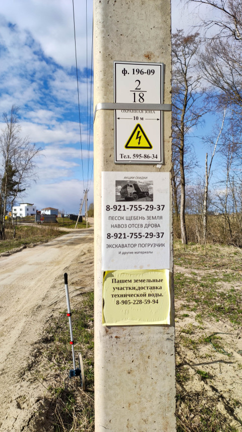 Объявления и указатели на столбе у дороги