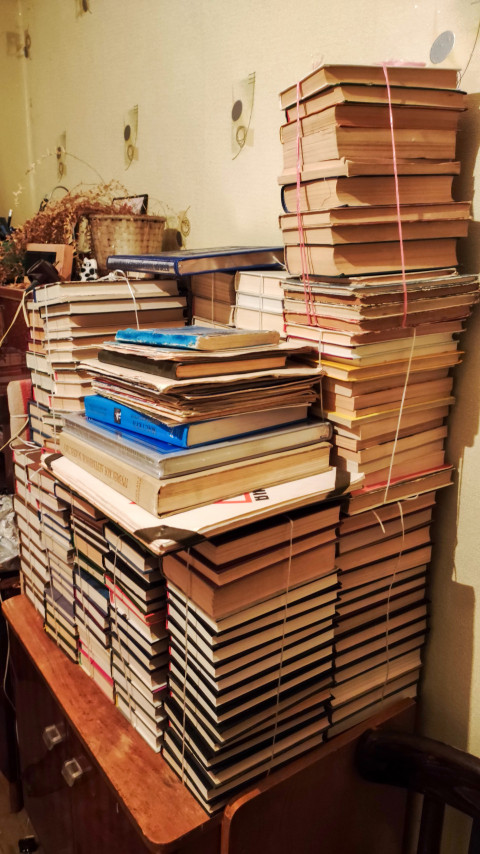 Стопка старых книг, перевязанных шпагатом на деревянной мебели