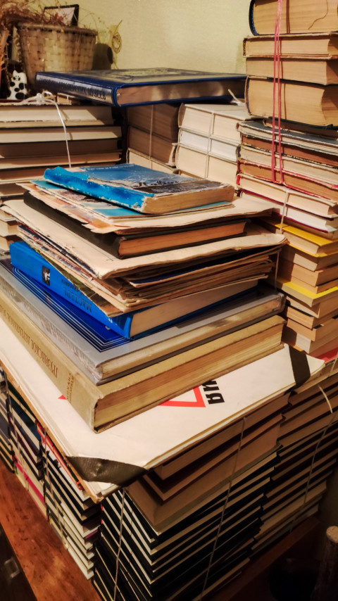 Стопка старых и новых книг на деревянной мебели