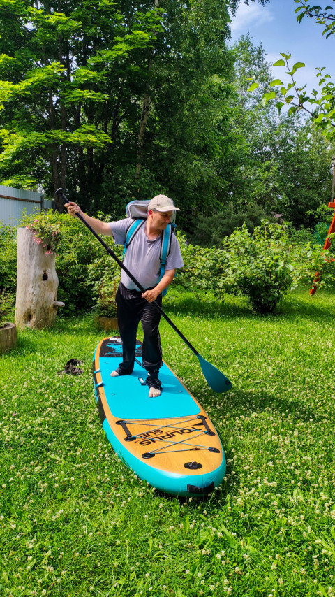 Мужчина тренируется с веслом на SUP-доске