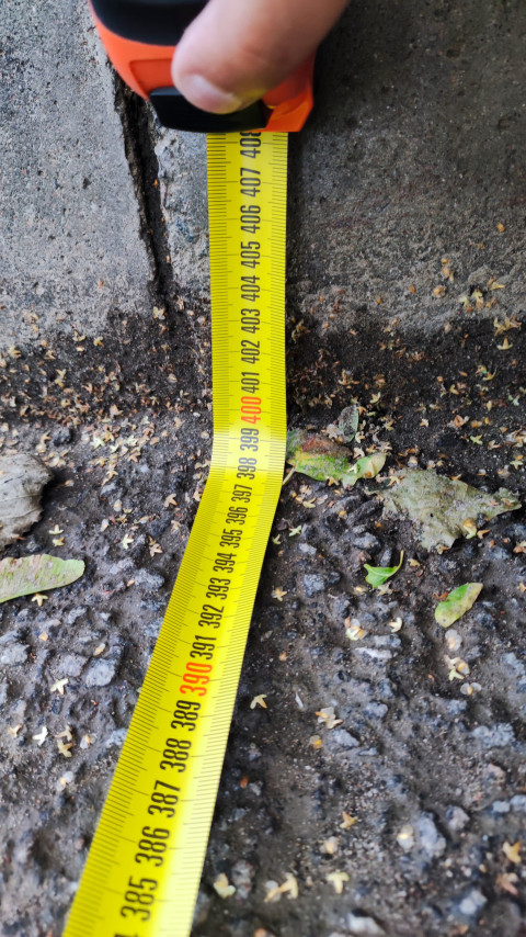 Измерение расстояния рулеткой вдоль бордюра