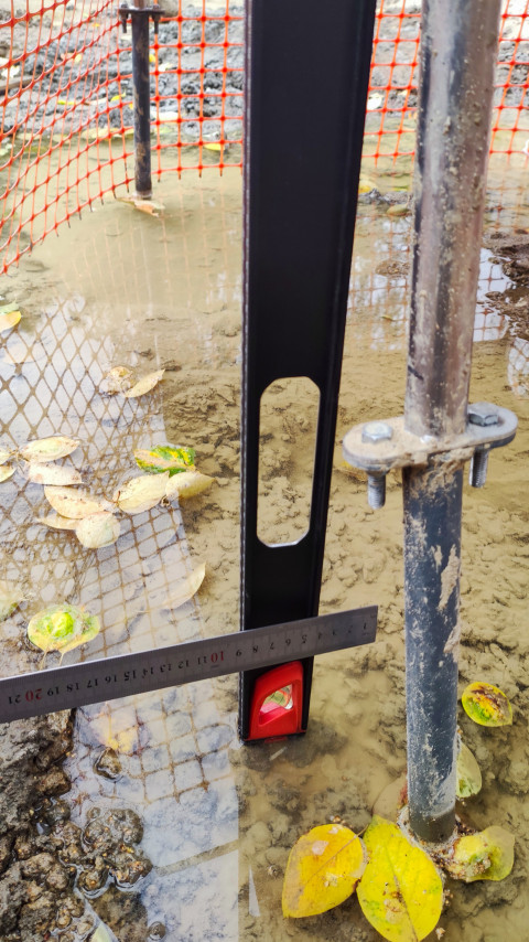 Замер расстояния между элементами конструкции горки на стройплощадке