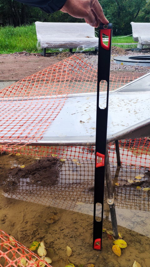 Проверка уклона горки на детской площадке строительным уровнем