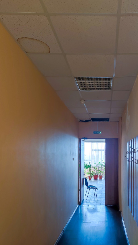 Коридор с подвесным потолком и крупным пятном от протечки