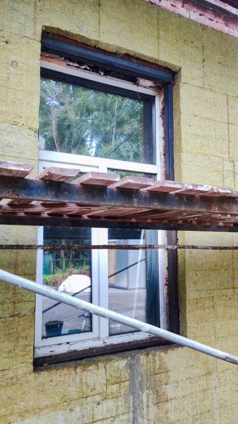 Окно здания в процессе утепления фасада каменной ватой