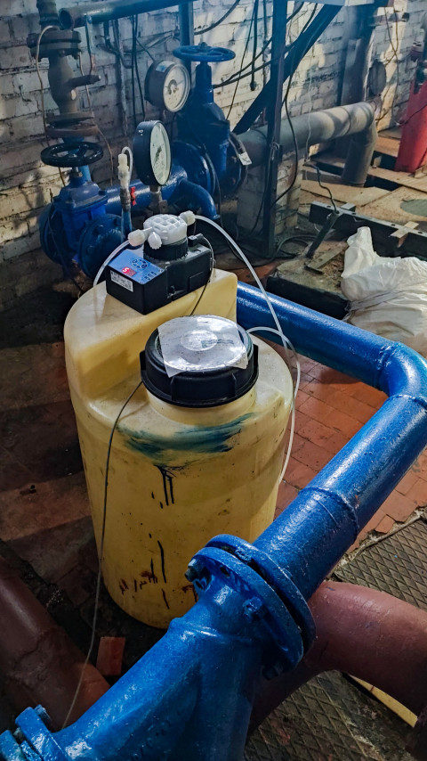 Емкость с насосом и инженерные коммуникации в техническом помещении
