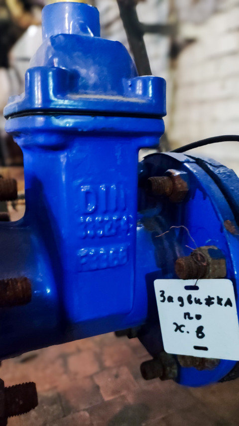 Синяя задвижка на трубопроводе с биркой