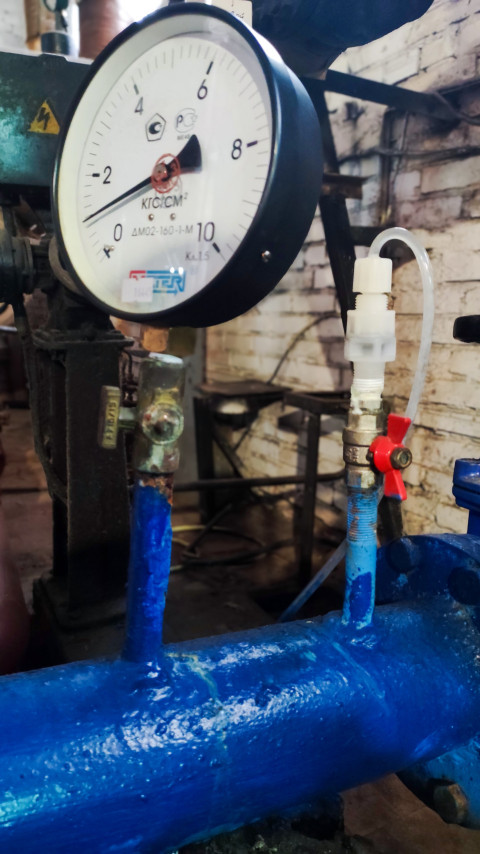 Манометр с подводом жидкости на трубе в техническом помещении