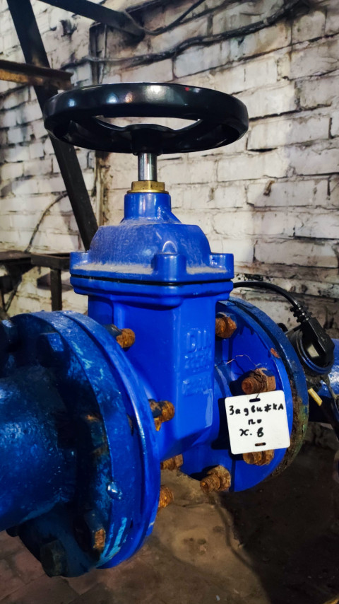 Синяя задвижка на трубопроводе с маркировочной биркой