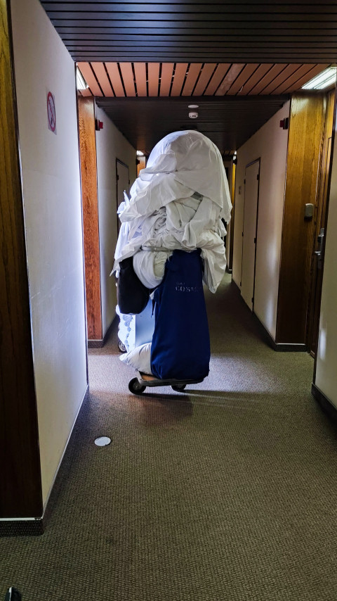 Тележка с постельным бельём в гостиничном коридоре