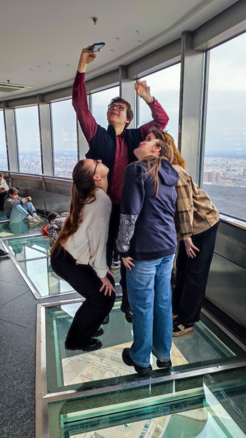 Группа посетителей на стеклянном полу смотровой площадки Останкинской башни