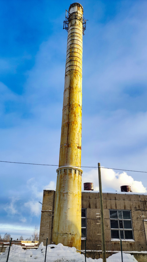 Высокая заводская труба перед синим небом