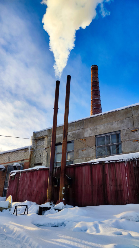Вертикальные дымоходы и кирпичная труба на зимней производственной площадке