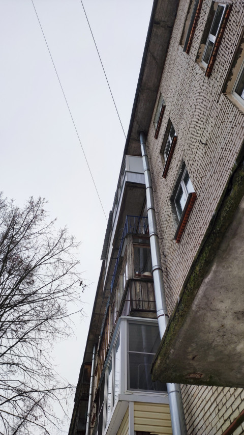 Кирпичная торцевая стена пятиэтажного дома с балконами