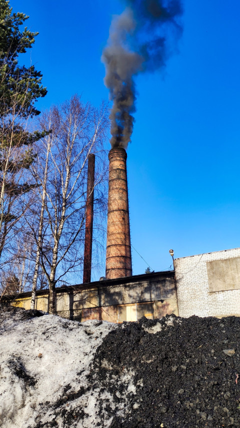 Промышленная труба с дымом и снежной массой на переднем плане