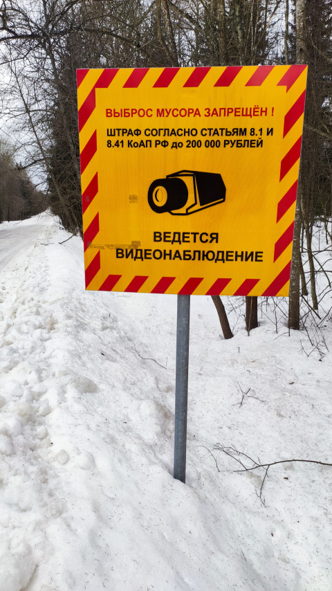 Знак о видеонаблюдении и запрете выброса мусора в заснеженном лесу