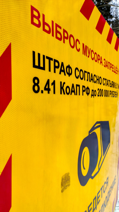 Информационный знак о запрете выброса мусора, установленный у зимней дороги