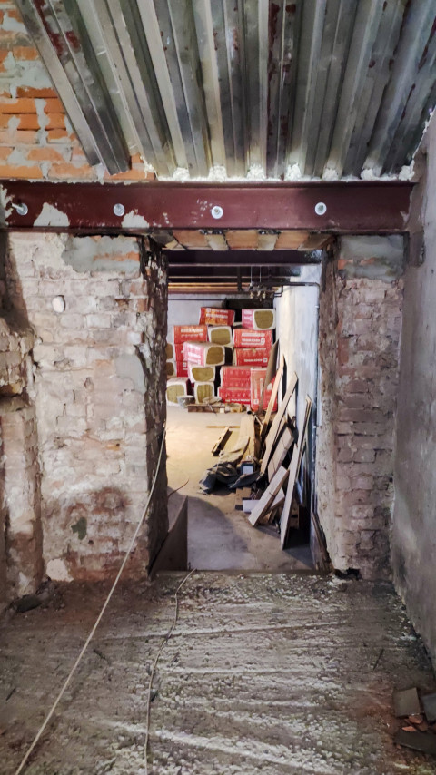 Подвал старого здания с кирпичными стенами и утеплителем