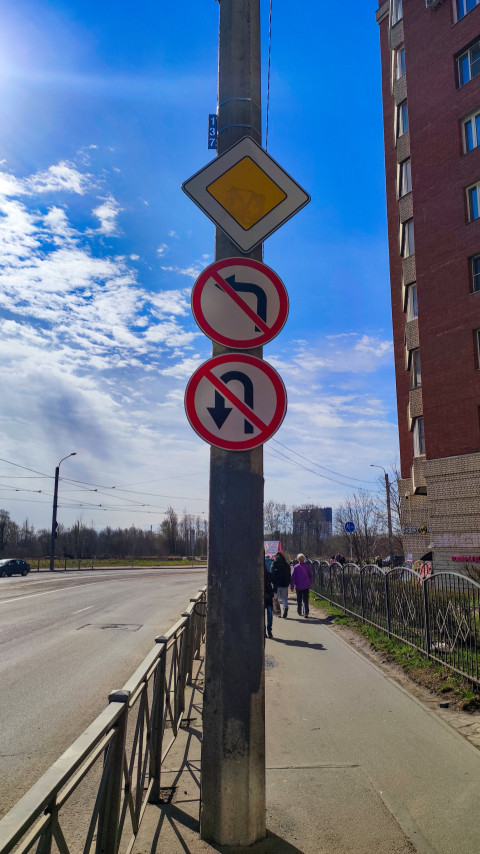 Дорожные знаки на опоре у жилого дома