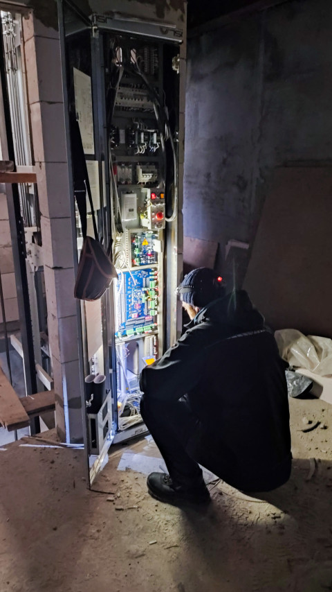 Специалист производит диагностику электрооборудования в техническом помещении