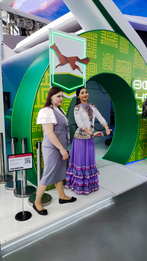 Сотрудницы стенда региона у декоративной арки в павильоне №75 ВДНХ