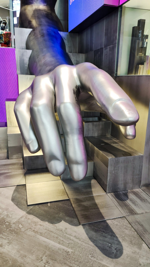 Металлизированная скульптура руки в выставочном пространстве