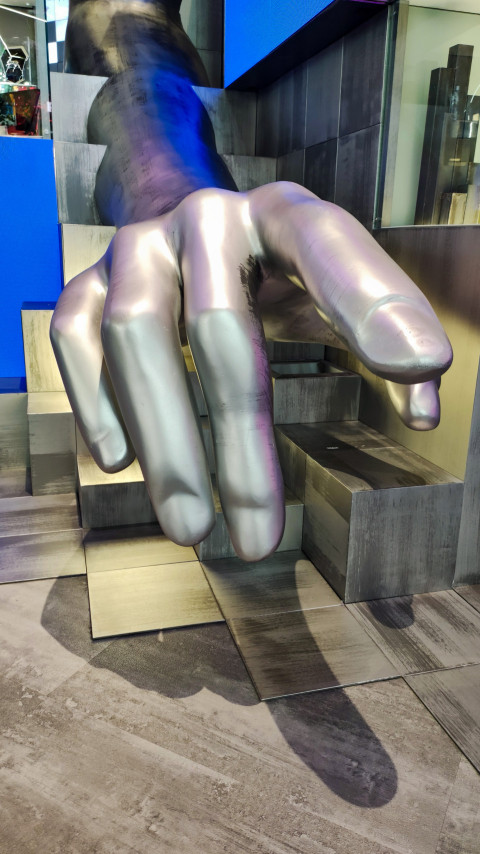 Крупная скульптура руки на металлической платформе