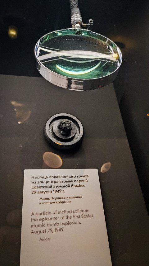 Экспонат с моделью оплавленного грунта под увеличительной линзой