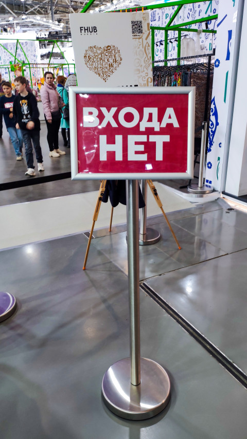 Стойка с табличкой «Входа нет» на фоне посетителей